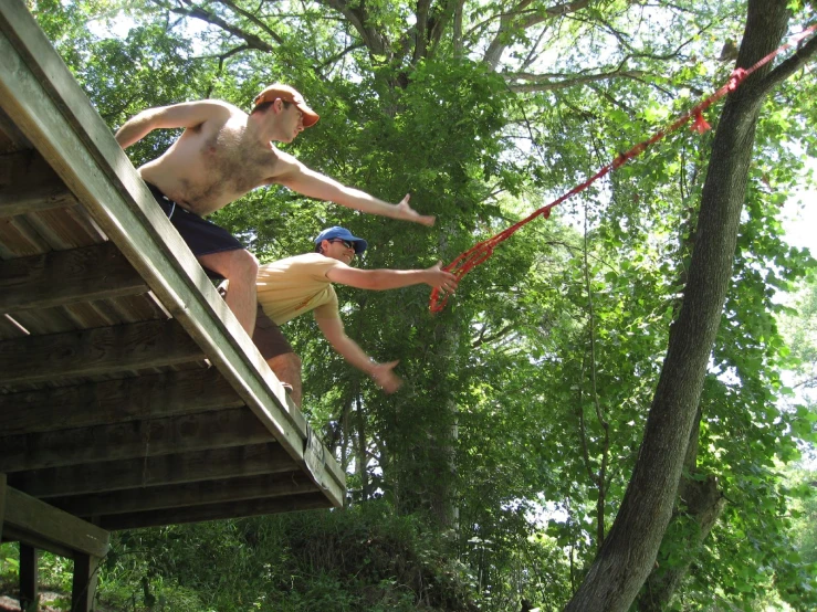 a man is doing a trick on a board while he climbs up a ledge