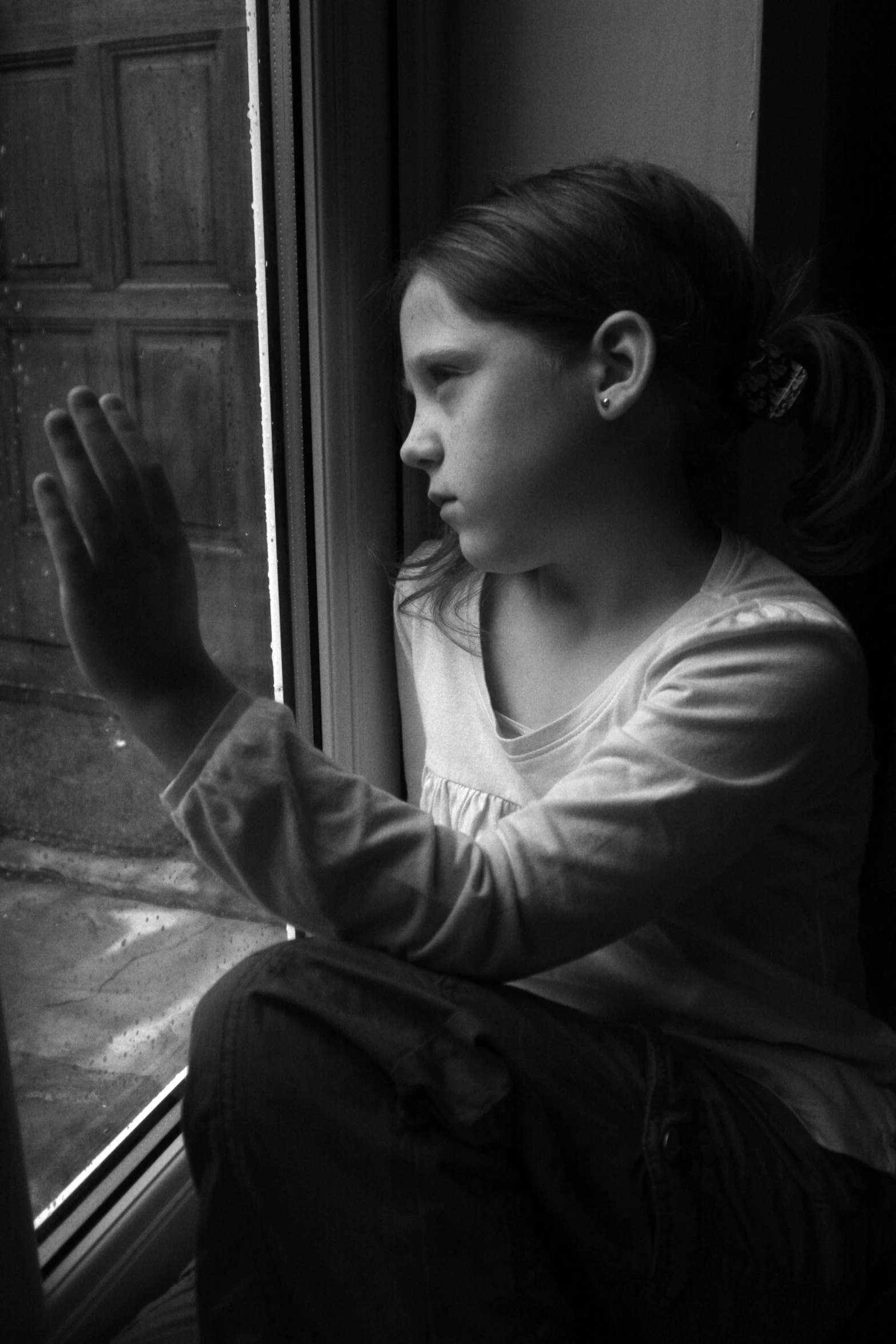 a young woman looks out the window while praying