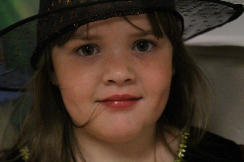 a girl in a black hat smiling for the camera