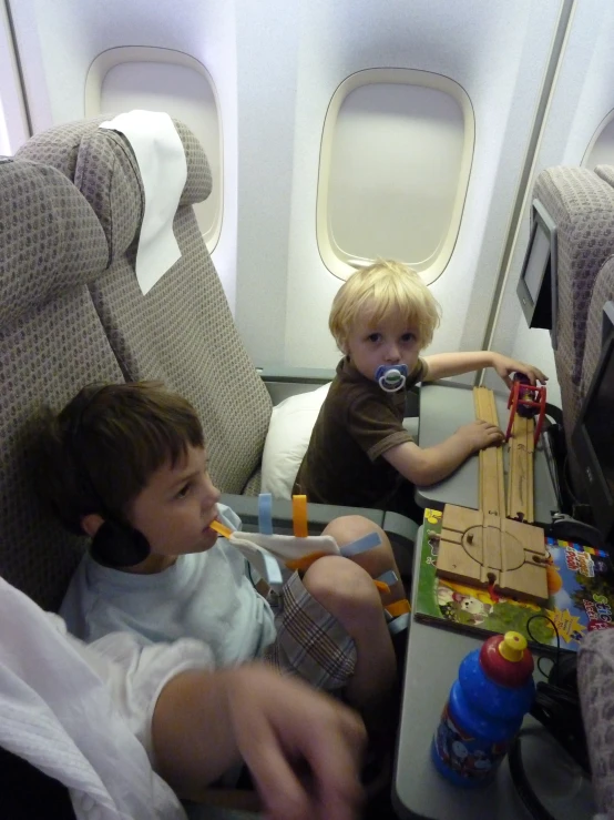 two little boys on an airplane playing with toys