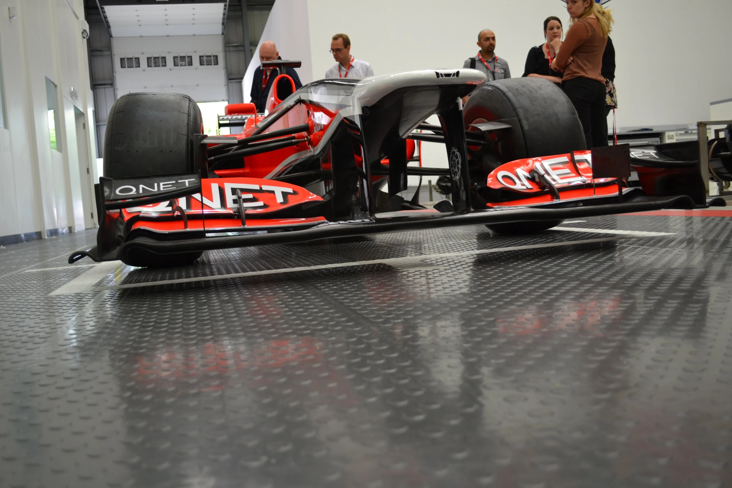 a car is shown on a display table with people in the background