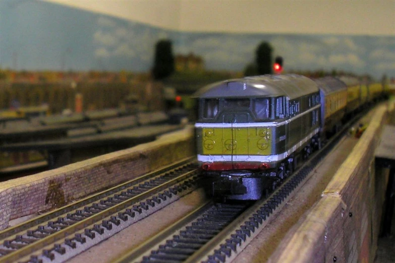 a model train on a track with buildings in the background