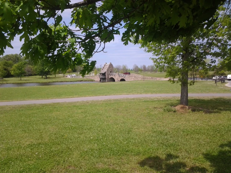 a path in front of an old structure near a field with water