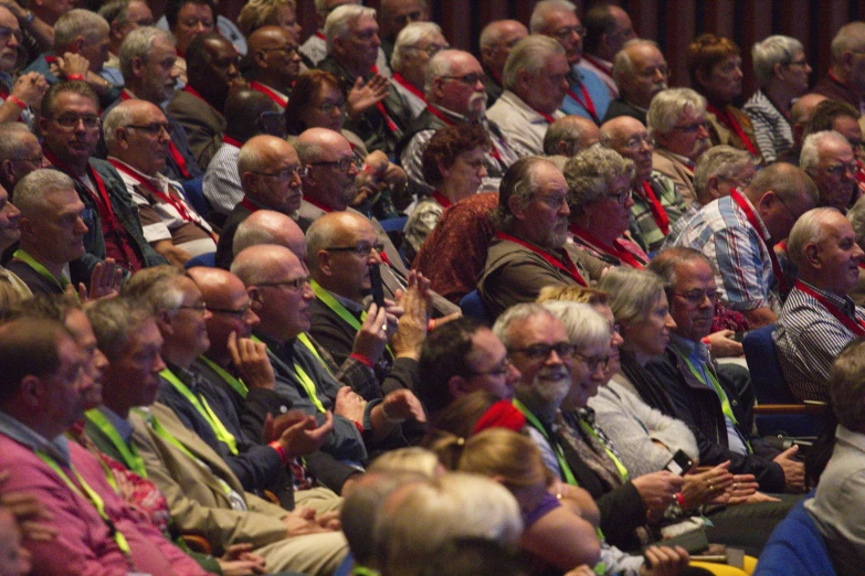 large group of people in audience with colorful ribbons