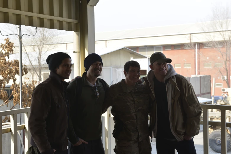 five guys are standing near each other on the porch