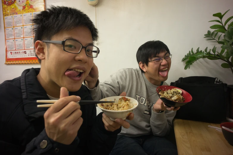 a couple of young people that are sitting in front of a bowl