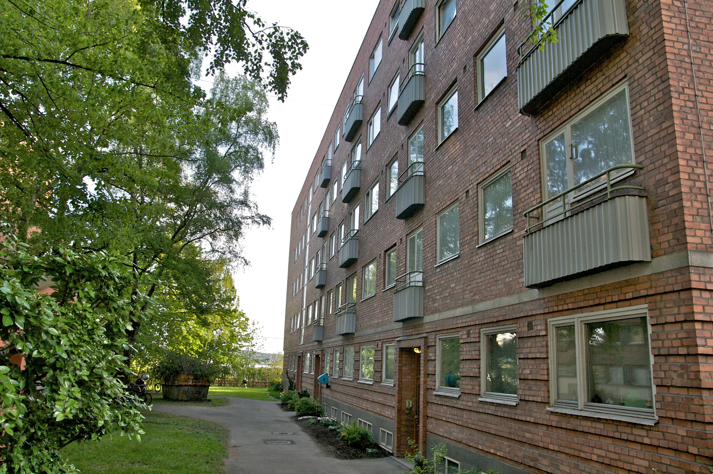 a paved pathway leads to a tall brick building