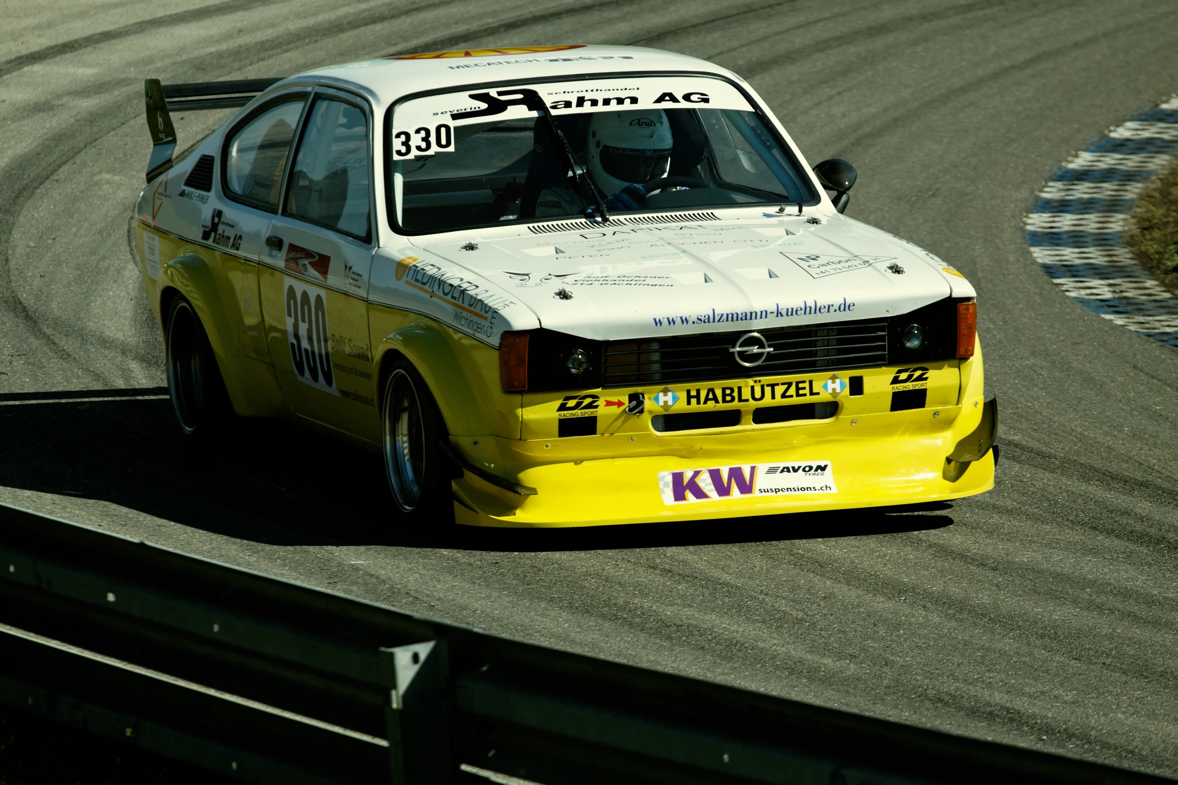 a yellow race car driving down a winding road