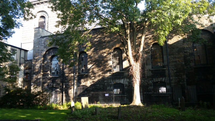 a large, old church with a tower behind a gated fence