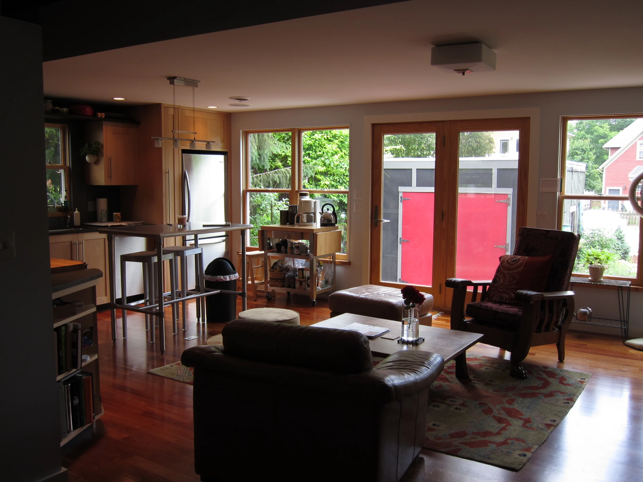 an empty living room with wood floors and open windows