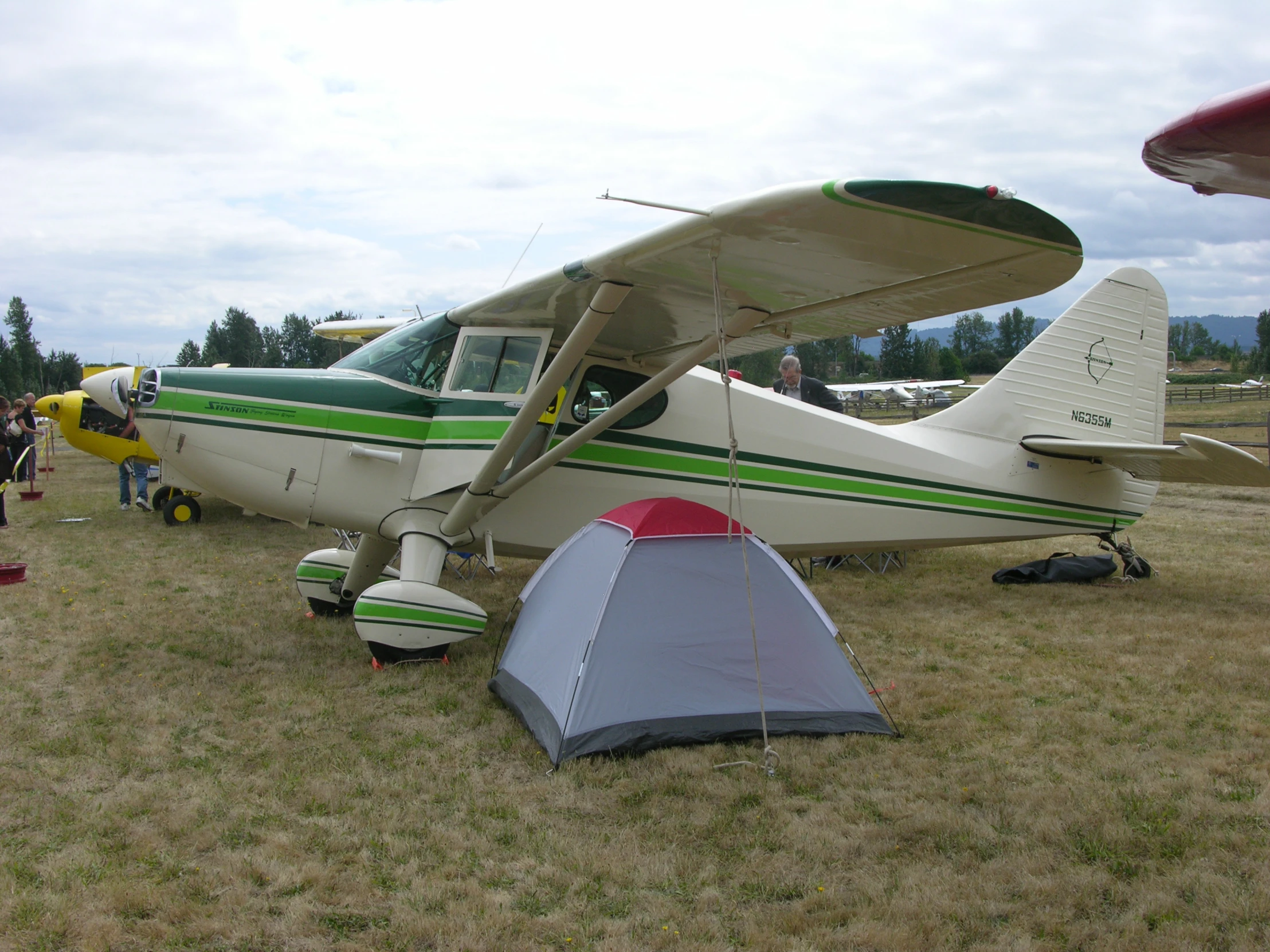 an airplane and tent in the middle of a field