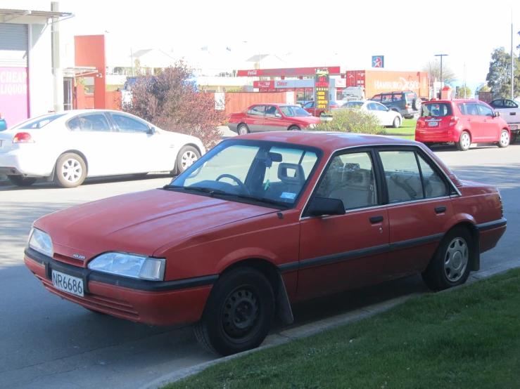 red car on road near cars and buildings