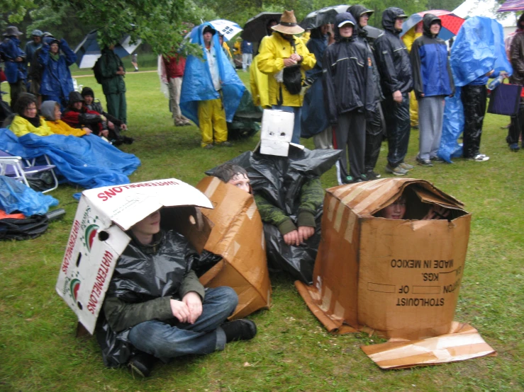 people on a grassy field with a large group wearing raincoats