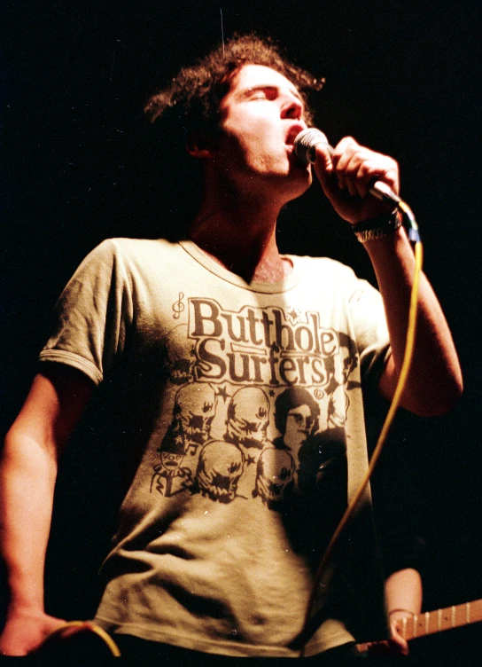 a young man standing in front of a microphone on stage