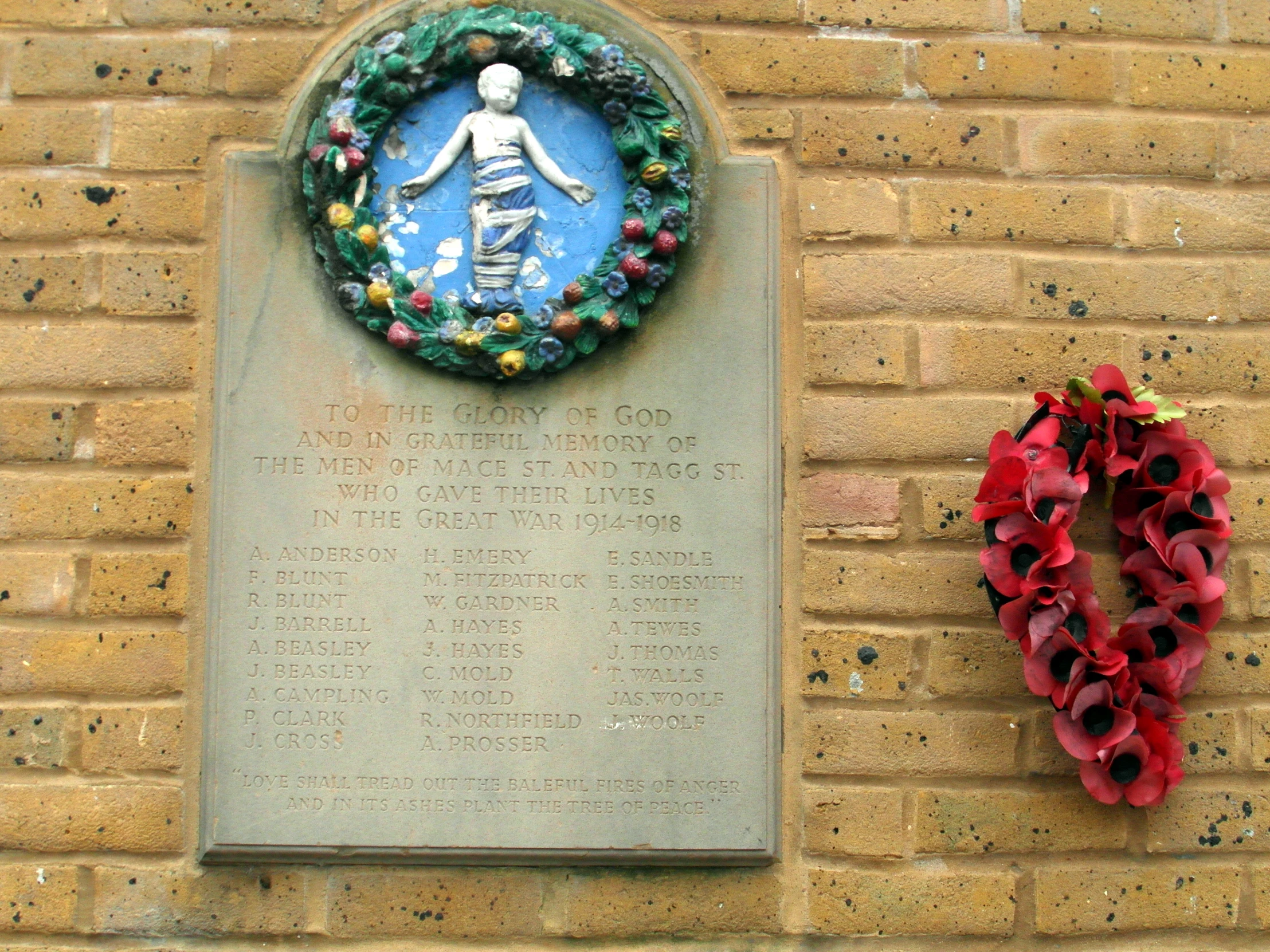 a wreath and a wall with flowers placed in front of it