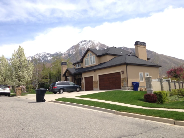 a large driveway leading into a home with a mountain in the background