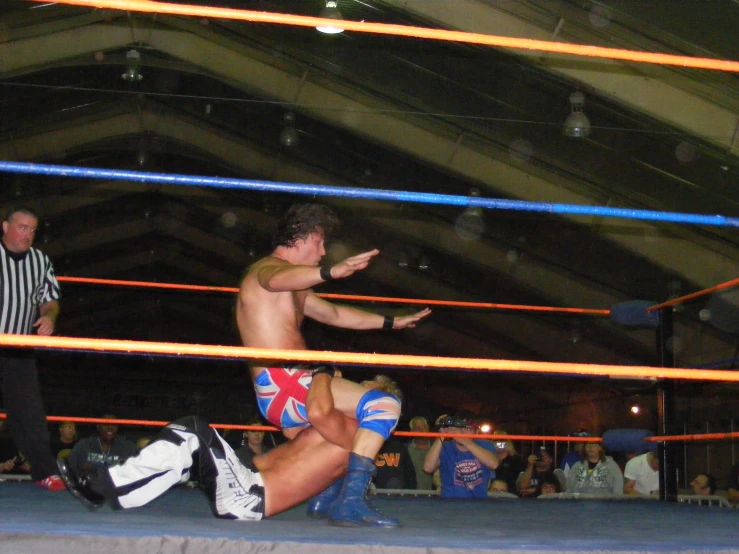 a couple of men standing next to each other in a wrestling ring