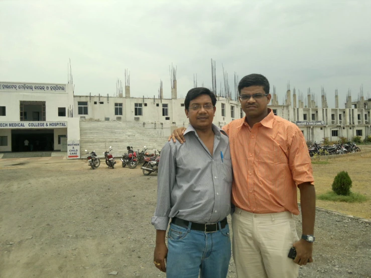 two men are standing together in front of a building