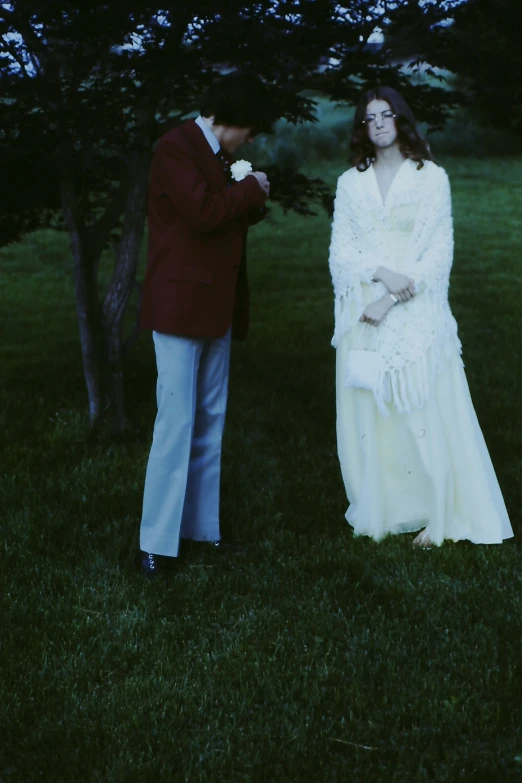 a man and a woman are standing in the grass