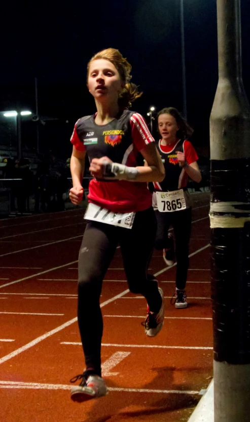 two girls are competing in a race at night