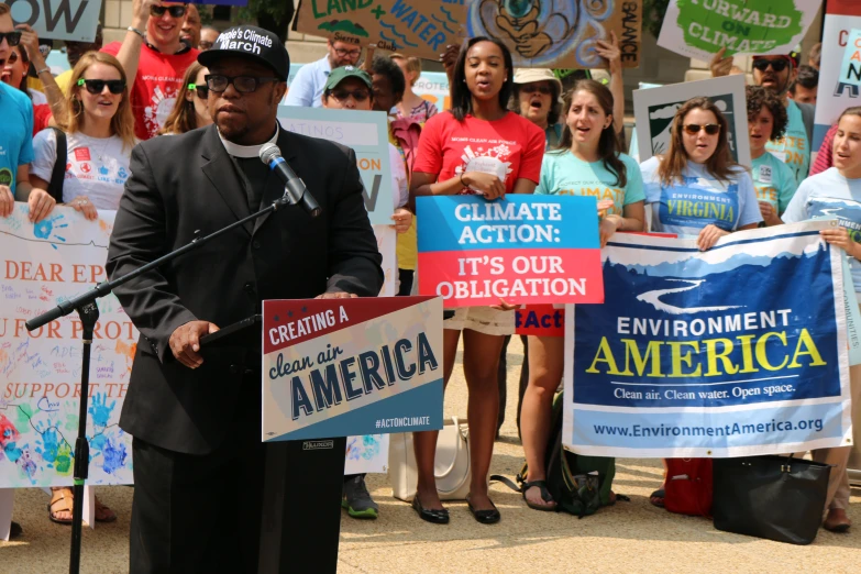 a man standing at a podium while holding signs