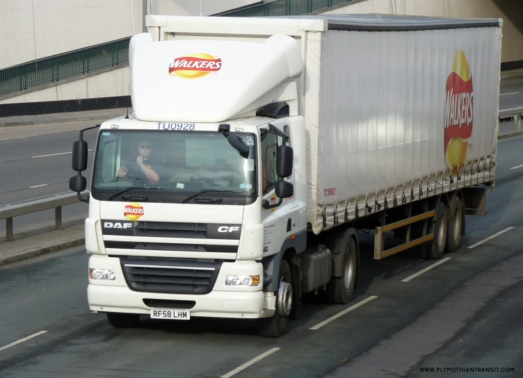 a white truck driving down the road next to a building