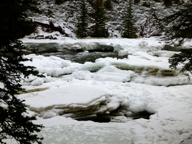 there is a stream of water that is covered with snow