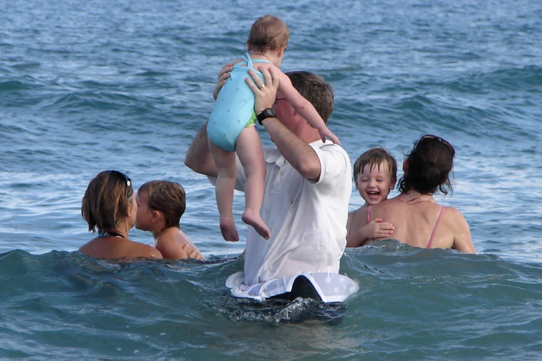 there is a man holding a small child in the water