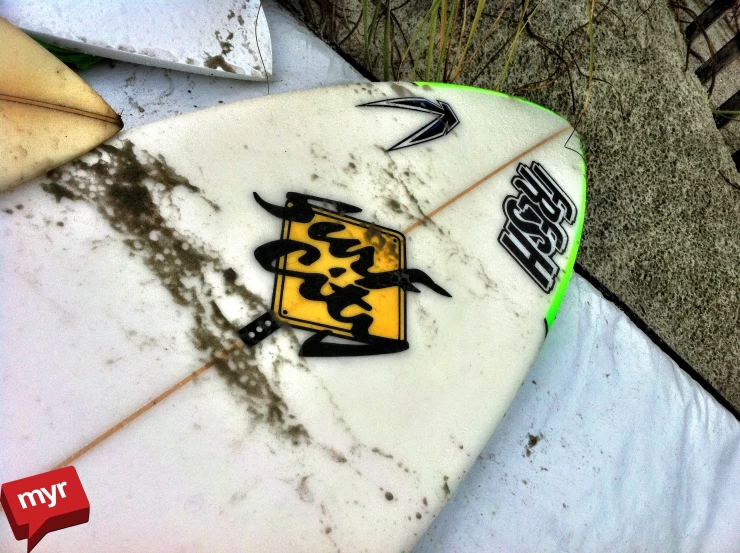 the underside of a white surfboard with yellow and black design