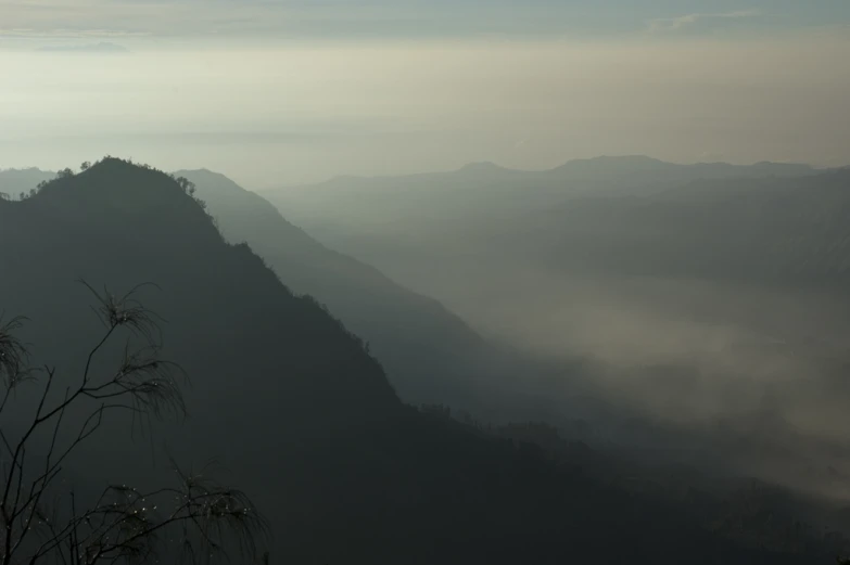 view of some mountains and fog covered hills