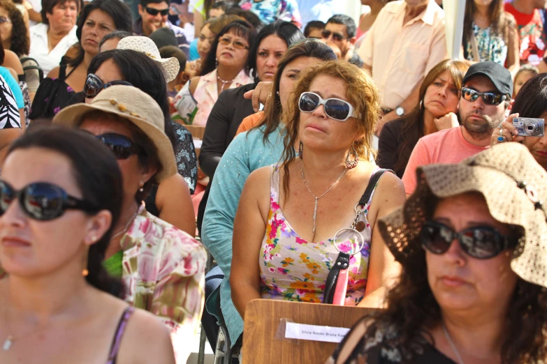 many women are wearing sunglasses and standing around