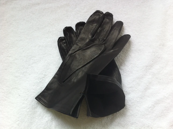 black gloves laying on a white cloth