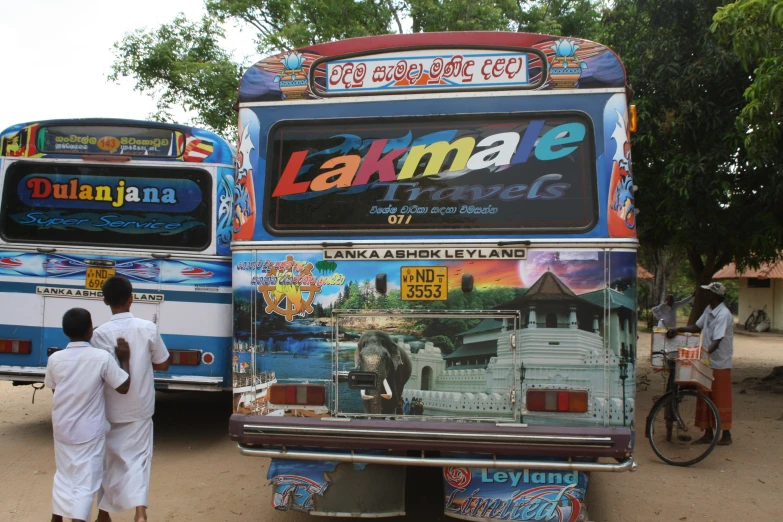 a man and boy walking by some colorful buses