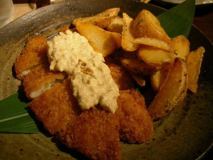 a plate with potatoes and seaweed and a sauce on top