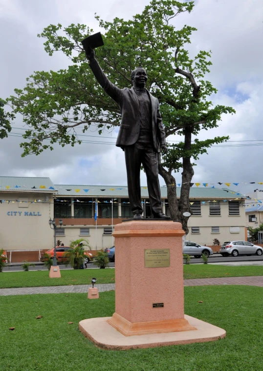 the statue is in the grass next to a tree