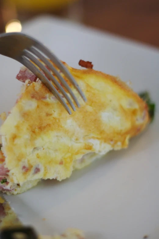 a fork is being used to take a piece of cheesy bread