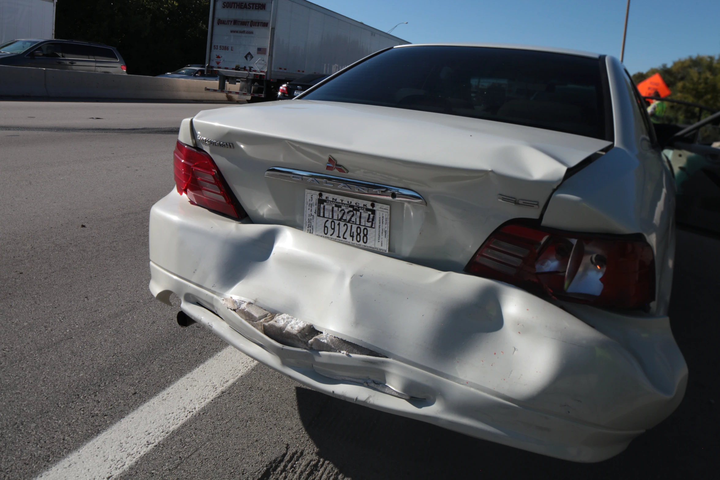 the rear end of a white car in a parking lot