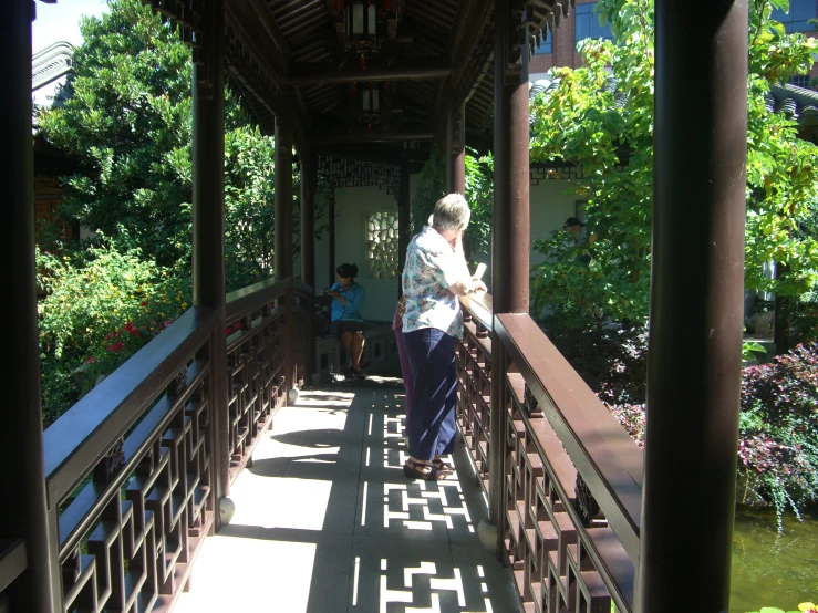 an elderly woman in a white blouse on a bridge