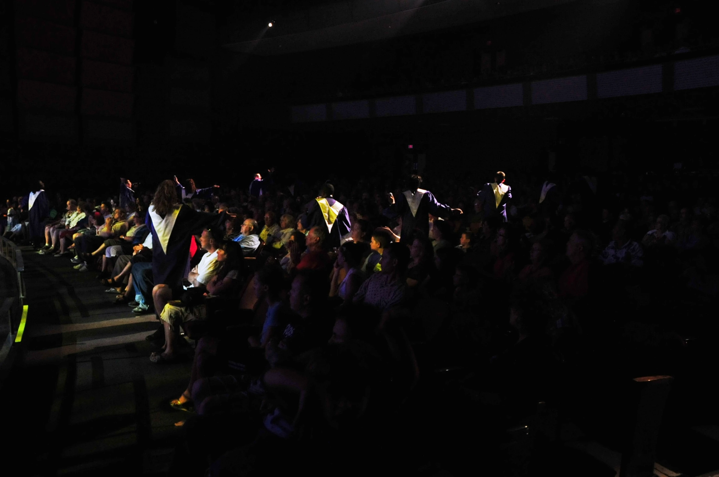 crowd of people at an auditorium watching and listening