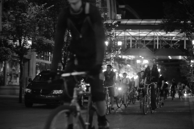 several people riding bicycles at night in a public area