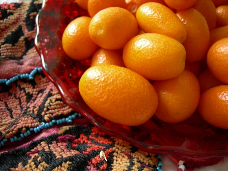 a bowl filled with lots of oranges on top of a table