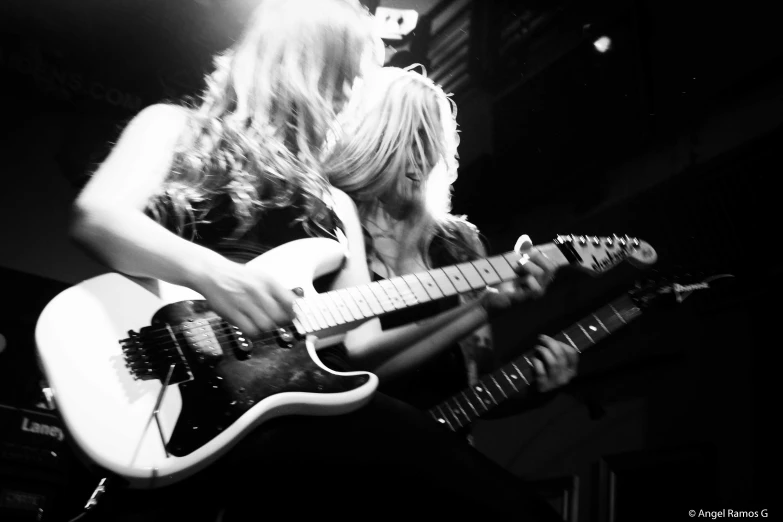 the blond lady is playing her guitar with her hand