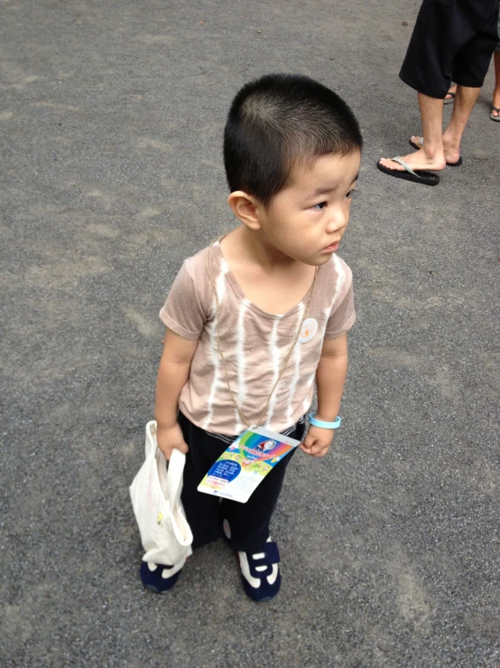 a small child holding a bag is standing by someone