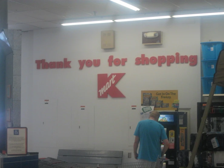 a person in a blue shirt is walking past a sign