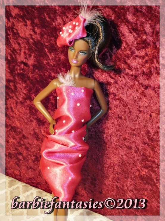 a barbie doll posed in pink dress and feather