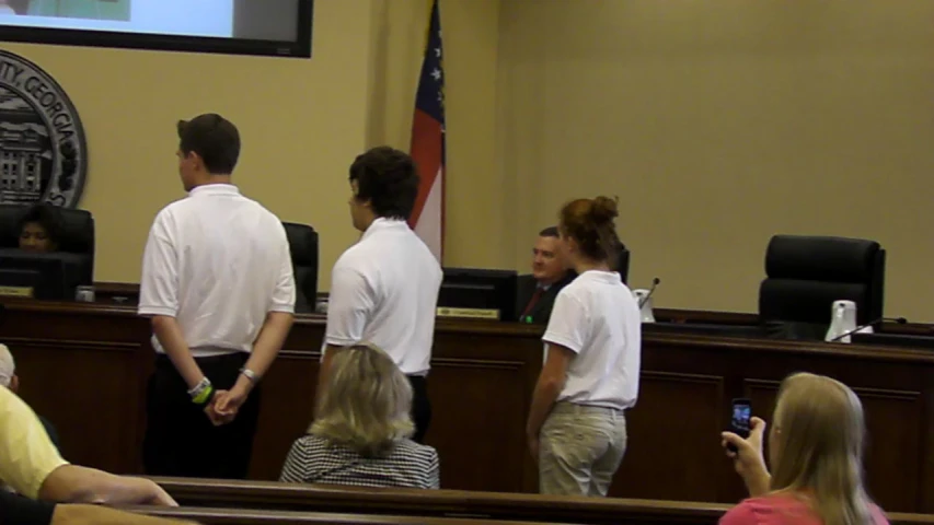 group of people in front of a screen in a courtroom