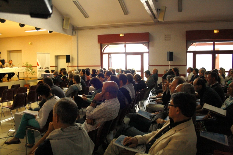 an auditorium filled with people with laptops in it