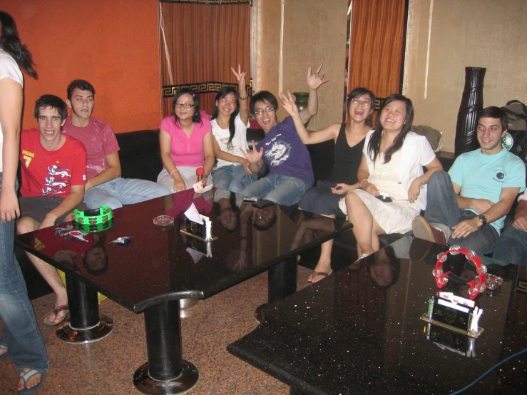 a group of young people sitting around a large wooden table