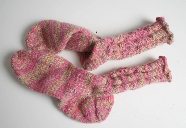 the pink and brown knitted mittens are made with wool
