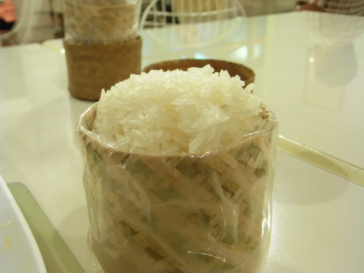 a jar with rice sitting on top of a white table